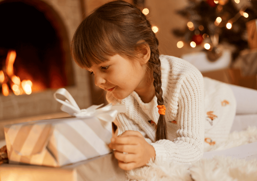 side-view-portrait-cute-female-kid-wearing-white-sweater-santa-claus-hat-posing-festive-room-with-fireplace-xmas-tree-playing-near-new-year-present-boxes (1)